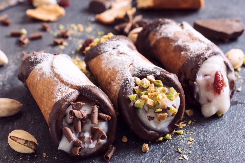 Cannoli sycylijskie, słodkie rurki wypełnione kremem ricotta